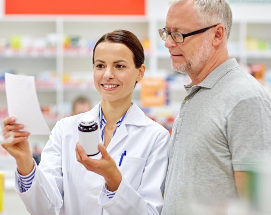 Ricker Pharmacy pharmacist reviewing a prescription face-to-face with a patient